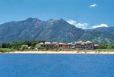 a resort on a beach with mountains in the background at Les Marines de Moriani in San-Nicolao
