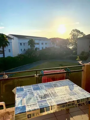 a table on a balcony with a view of a building at Les Marines de Moriani in San-Nicolao