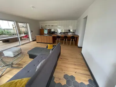 a living room with a couch and a kitchen at Villa-de Luxe-Salle de bain-Vue sur la campagne à 5 minutes de la mer Qui est composé de 5 chambres in Venzolasca