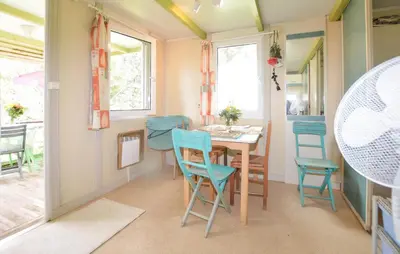 a dining room with a table and blue chairs at Gorgeous Stacaravan In Casalabriva in Casalabriva