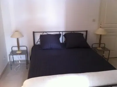 a bedroom with a bed with blue pillows and two lamps at U Paesu in Zonza