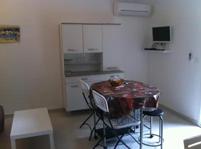 a kitchen with a table and chairs in a room at U Paesu in Zonza