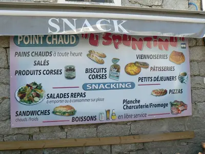 a sign for a fast food restaurant on a wall at U Paesu in Zonza