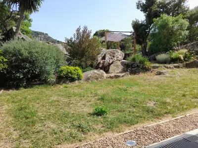 a garden with rocks and plants in a yard at Maison de campagne idéale pour séjour en famille in Porto-Vecchio