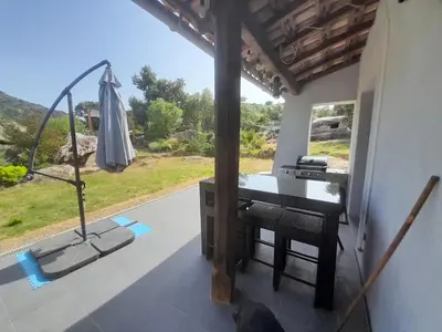 a room with a desk and an umbrella and a window at Maison de campagne idéale pour séjour en famille in Porto-Vecchio