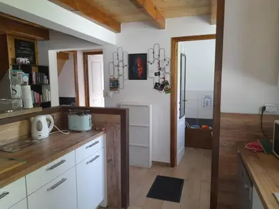 a kitchen with white cabinets and a wooden counter top at Maison de campagne idéale pour séjour en famille in Porto-Vecchio