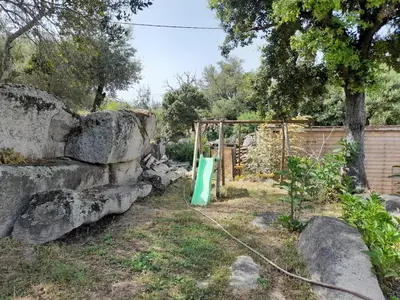a garden with a stone wall and a gate at Maison de campagne idéale pour séjour en famille in Porto-Vecchio