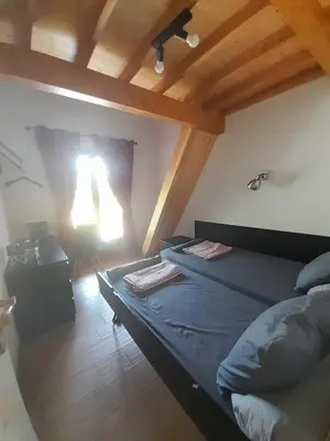 a bedroom with two beds in a room with wooden ceilings at Maison de campagne idéale pour séjour en famille in Porto-Vecchio