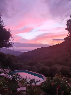 a swimming pool with a sunset in the mountains at Fozzano in Fozzano