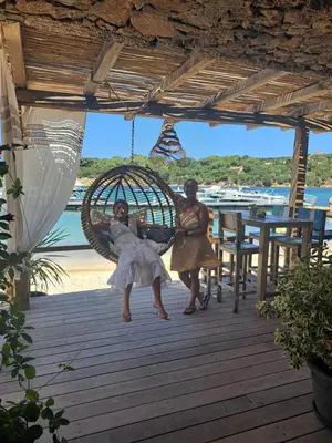two women sitting in a swing on a beach at Fozzano in Fozzano