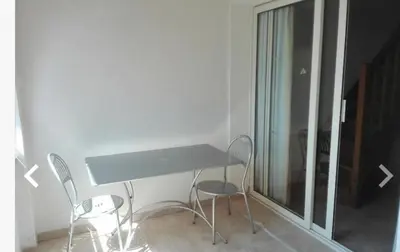 a desk in a room with two chairs and a window at Appartement avec piscine in Linguizzetta
