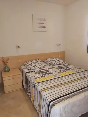 a bedroom with a bed with a striped comforter at Appartement avec piscine in Linguizzetta