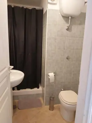 a bathroom with a toilet and a sink and a shower at Appartement avec piscine in Linguizzetta