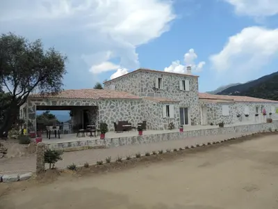 an old stone building with a patio in front at Maquis et Mer in Sollacaro
