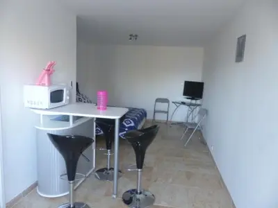 a room with a table and chairs and a microwave at Maquis et Mer in Sollacaro