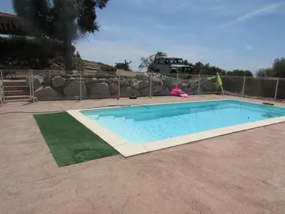 a swimming pool in a yard next to a fence at Maquis et Mer in Sollacaro