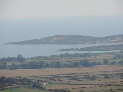 a large field with a large body of water at Maquis et Mer in Sollacaro