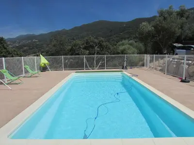 a large blue swimming pool with at Maquis et Mer in Sollacaro