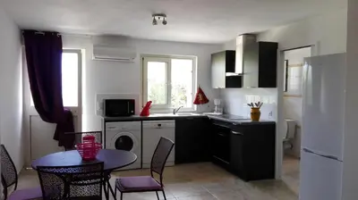 a kitchen with a sink and a table with chairs at Maquis et Mer in Sollacaro