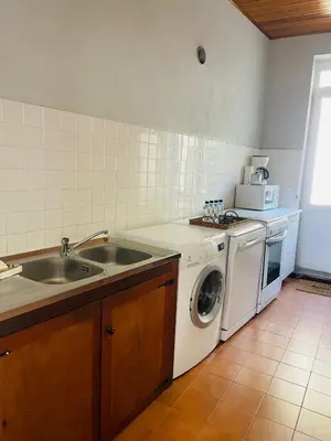 a kitchen with a sink and a washing machine at Grande Maison de village ZONZA in Zonza