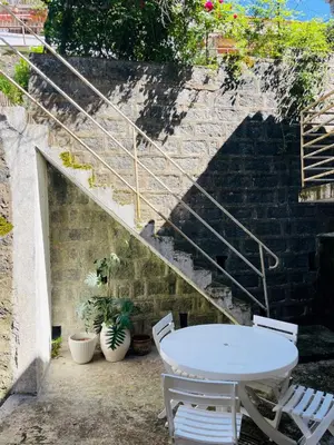 a patio with a table and chairs and stairs at Grande Maison de village ZONZA in Zonza