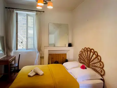 a bedroom with a bed with a yellow blanket at Grande Maison de village ZONZA in Zonza