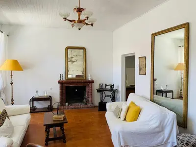 a living room with a white couch and a mirror at Grande Maison de village ZONZA in Zonza