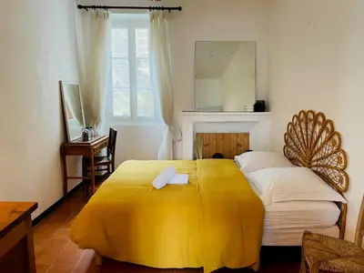 a bedroom with a large bed with a yellow blanket at Grande Maison de village ZONZA in Zonza
