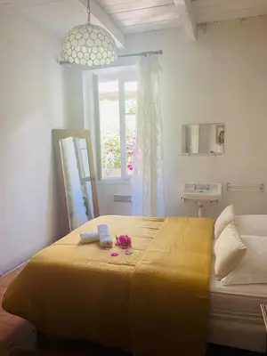 a bedroom with a large yellow bed with a window at Grande Maison de village ZONZA in Zonza