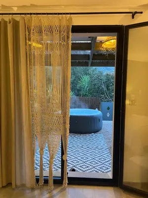 a sliding glass door with curtains open to a patio at Bas de Villa indépendant San Benedetto in Alata