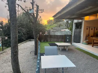 two people standing in the backyard of a house with a table at Bas de Villa indépendant San Benedetto in Alata