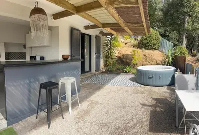 a patio with a tub and a table and chairs at Bas de Villa indépendant San Benedetto in Alata