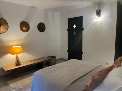 a bedroom with a bed and a table and a lamp at Bas de Villa indépendant San Benedetto in Alata