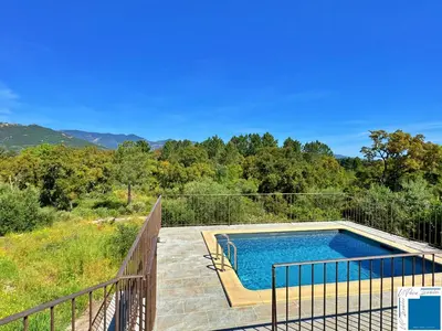 a swimming pool on a deck next to a fence at A Sérénità - Bergerie - Piscine Privée in Porto-Vecchio