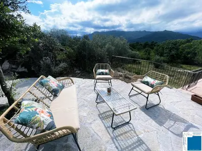 a patio with three chairs and a table with a view at A Sérénità - Bergerie - Piscine Privée in Porto-Vecchio