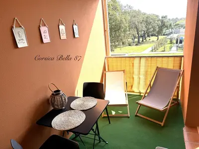 a balcony with a table and chairs and a window at Corsica Bella 87 T2 Cosy piscines proche plage in Lecci