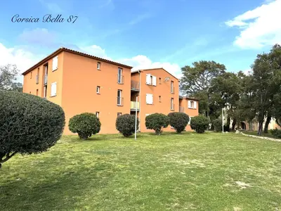 a large building with bushes in front of it at Corsica Bella 87 T2 Cosy piscines proche plage in Lecci