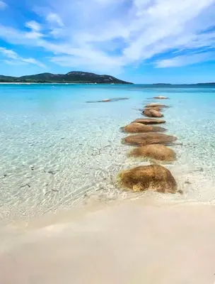 a group of rocks sticking out of the water on a beach at Corsica Bella 87 T2 Cosy piscines proche plage in Lecci