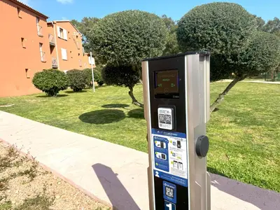 a parking meter sitting on the side of a sidewalk at Corsica Bella 87 T2 Cosy piscines proche plage in Lecci