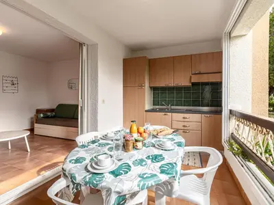 a table and chairs in a room with a kitchen at Apartment Casa Antonio by Interhome in Linguizzetta