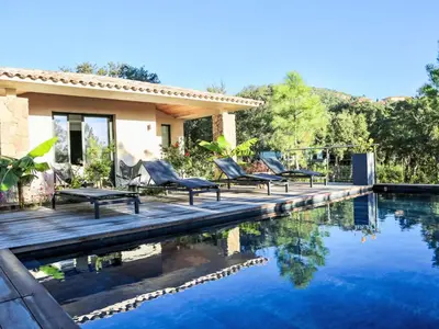 a group of chairs sitting on a deck next to a pool at Villa La Cupulatta by Interhome in Sainte-Lucie de Porto-Vecchio
