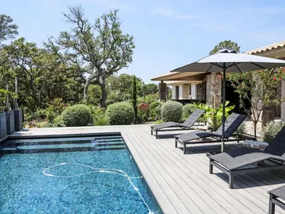 a swimming pool with two chairs and an umbrella at Villa La Cupulatta by Interhome in Sainte-Lucie de Porto-Vecchio