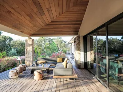 a patio with a couch and chairs on a wooden deck at Villa La Cupulatta by Interhome in Sainte-Lucie de Porto-Vecchio