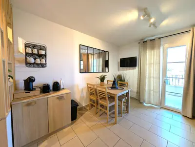 a kitchen with a table and a dining room at Appartement cosy Vue Mer et Montagne in Sari Solenzara