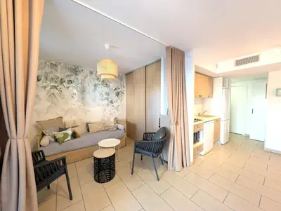 a living room with a bed and a table and chairs at Appartement cosy Vue Mer et Montagne in Sari Solenzara