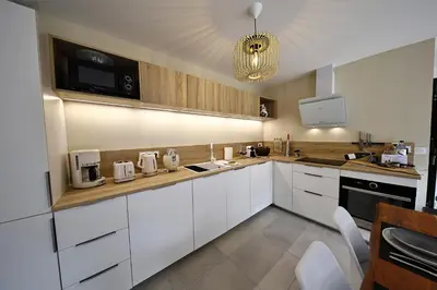 a kitchen with white cabinets and white appliances at U Sognu - Superbe T3 à Bonifacio classé 4 étoiles in Bonifacio