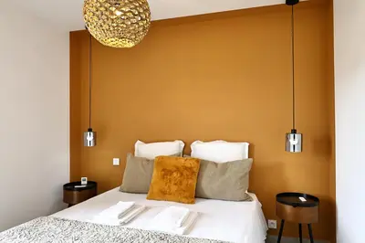 a bedroom with a bed with a yellow wall at U Sognu - Superbe T3 à Bonifacio classé 4 étoiles in Bonifacio