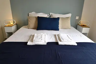 a blue and white bed with two towels on it at U Sognu - Superbe T3 à Bonifacio classé 4 étoiles in Bonifacio