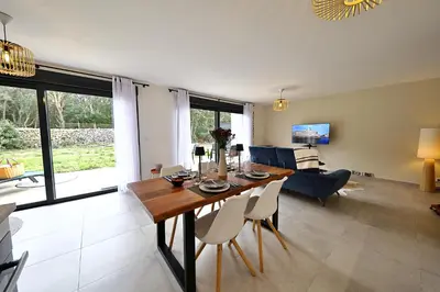 a dining room and living room with a table and chairs at U Sognu - Superbe T3 à Bonifacio classé 4 étoiles in Bonifacio