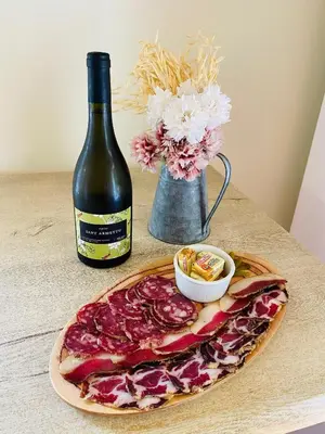 a table with a pizza and a bottle of wine at Gite d'étape Auberge Luna Piena in Santa-Reparata-di-Moriani
